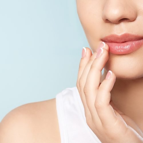 Young woman with sexy lips on color background, closeup